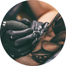 Lade das Bild in den Galerie-Viewer, Aluminiumbild gebürstet Künstler beim Tätowieren eines Tattoo Kreis