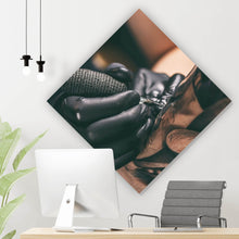 Lade das Bild in den Galerie-Viewer, Aluminiumbild gebürstet Künstler beim Tätowieren eines Tattoo Raute
