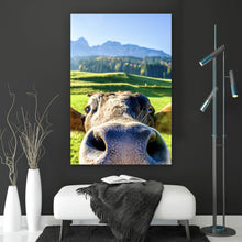 Lade das Bild in den Galerie-Viewer, Spannrahmenbild Neugierige Kuh auf grüner Wiese vor Berglandschaft Hochformat