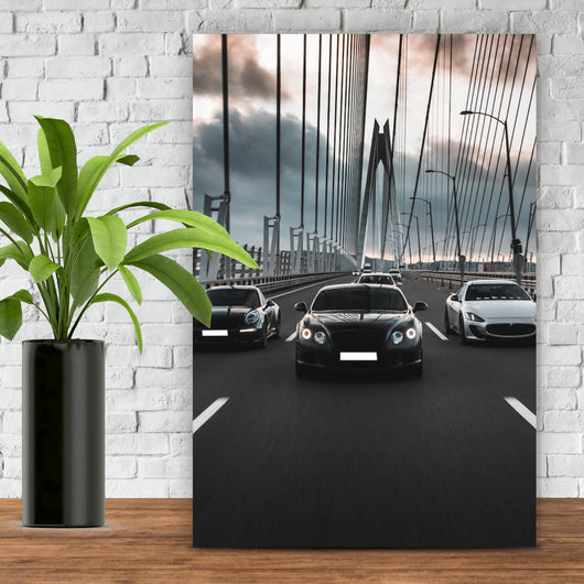 Leinwandbild Luxusautos in der Fahrt auf einer Brücke Hochformat