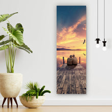 Lade das Bild in den Galerie-Viewer, Spannrahmenbild Paar auf Holzsteg bei Sonnenuntergang Panorama Hoch
