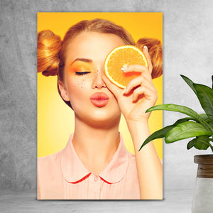 Leinwandbild Sommermädchen mit einer Orange Hochformat