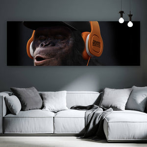 Spannrahmenbild Affe mit orangenen Kopfhörern Panorama